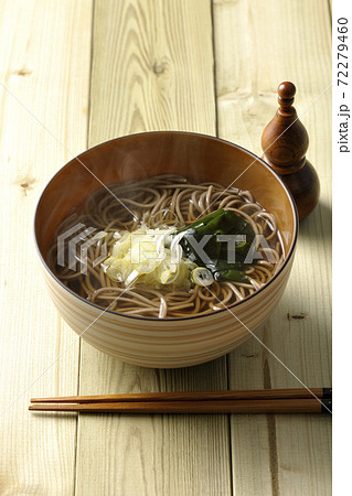刻み葱とわかめがトッピングされたシンプルな掛け蕎麦と瓢箪型の七味入れ 72279460