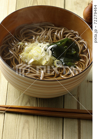 刻み葱とわかめがトッピングされたシンプルな掛け蕎麦と瓢箪型の七味入れ 72279464