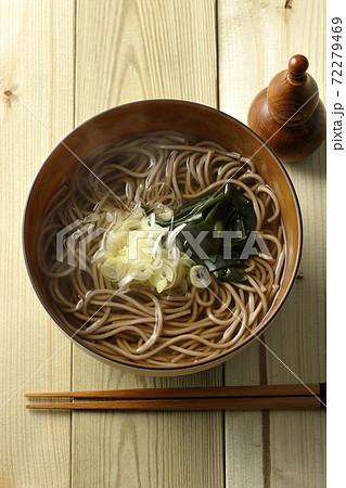 刻み葱とわかめがトッピングされたシンプルな掛け蕎麦と瓢箪型の七味入れ（俯瞰） 72279469