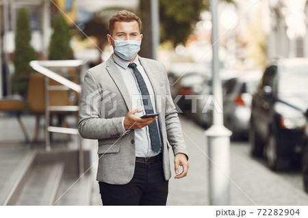 Businessman in a mask use the phone Businessman in a mask use the phone 72282904