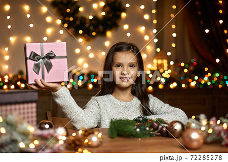 little child girl holding Christmas gift box little child girl holding Christmas gift box 72285278