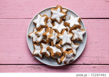 Icing gingerbread stars. Traditional Christmas cookies on pink wooden table. Icing gingerbread stars. Traditional Christmas cookies on pink wooden table. 72287462