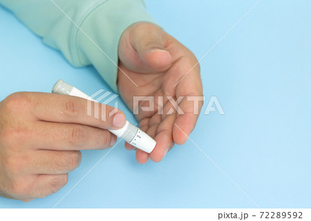 Diabetes test concept, man taking blood sample by lancet 72289592