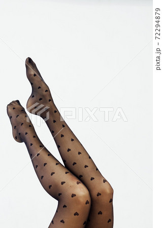 beautiful slender women's legs in black tights on a white background 72294879