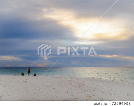 People on a sandy island at sunset in the Indian ocean near the Maldives 72294938