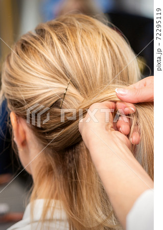 Hairdresser's hands braiding client's hair Hairdresser's hands braiding client's hair 72295119