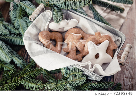 Gingerbread Christmas cookies and green fir branches on a rustic table. Homemade traditional New Year or Christmas sweet pastries. Top view Gingerbread Christmas cookies and green fir branches on a rustic table. Homemade traditional New Year or Christmas sweet pastries. Top view 72295349