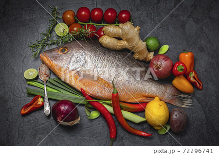 Raw Red snapper fish with spices and herbs ingredients for cooking on dark background., top view 72296741