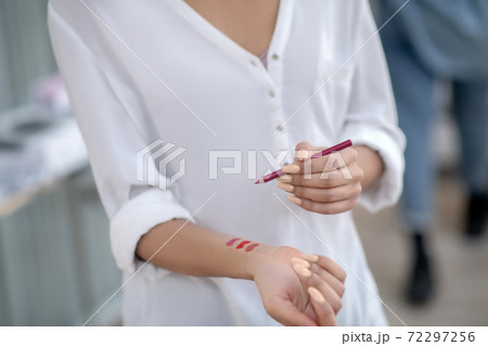 Female hands trying red lip liner on wrist Female hands trying red lip liner on wrist 72297256