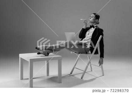 Young fashionable, stylish woman wearing jacket and socks working from home. Fashion during insulation 'cause of coronavirus pandemic Young fashionable, stylish woman wearing jacket and socks working from home. Fashion during insulation 'cause of coronavirus pandemic 72298370