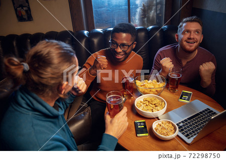 Excited fans with mobile app for betting and score on their devices. Gambling, emotions Excited fans with mobile app for betting and score on their devices. Gambling, emotions 72298750
