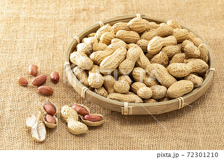 麻布の上にざるを置きその上に乗せた殻付きの落花生 72301210