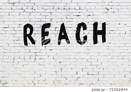 Word reach painted on white brick wall Word reach painted on white brick wall 72302844