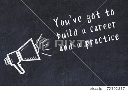 Chalk loudspeaker and wise quote on black desk 72302857