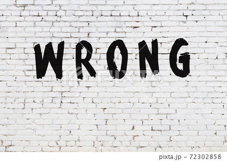 Word wrong painted on white brick wall 72302858