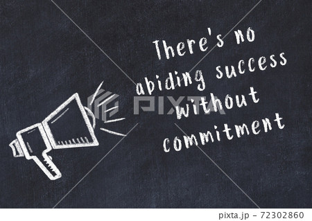 Chalk loudspeaker and wise quote on black desk 72302860