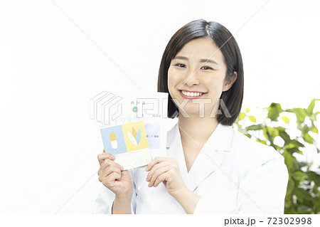 笑顔で薬袋とお薬手帳を持つ女性薬剤師 笑顔で薬袋とお薬手帳を持つ女性薬剤師 72302998