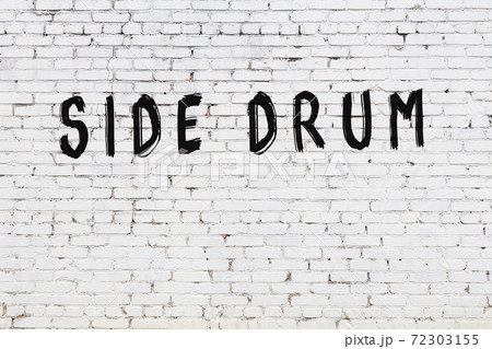 Word side drum painted on white brick wall 72303155
