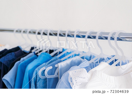 Fast fashion, Sustainable fashion, minimalist wardrobe. Variety of female blue clothing on hanging on white background with copy space. Fashion minimal style banner Fast fashion, Sustainable fashion, minimalist wardrobe. Variety of female blue clothing on hanging on white background with copy space. Fashion minimal style banner 72304639
