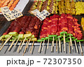 Different kind of meats on barbecue skewers are on the counter in a market in Thailand 72307350
