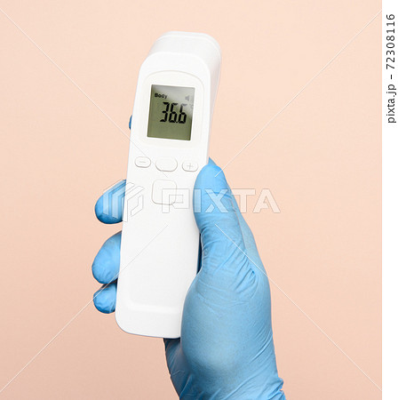 hand in blue latex gloves hold an electronic thermometer to measure temperature 72308116