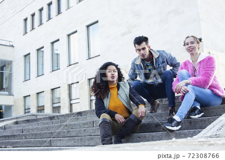 cute group of teenages at the building of university with books huggings, diversity nations real students lifestyle 72308766