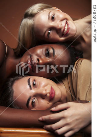 young pretty asian, caucasian, afro woman posing cheerful together on brown background, lifestyle diverse nationality people concept young pretty asian, caucasian, afro woman posing cheerful together on brown background, lifestyle diverse nationality people concept 72308781