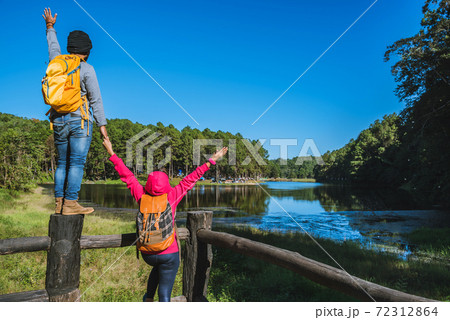 Couples travelers with backpack happy to relax on a holiday, travelers Pang-Ung park travel,Travel to visit nature landscape the beautiful at lake, at Mae-hong-son, in Thailand. 72312864
