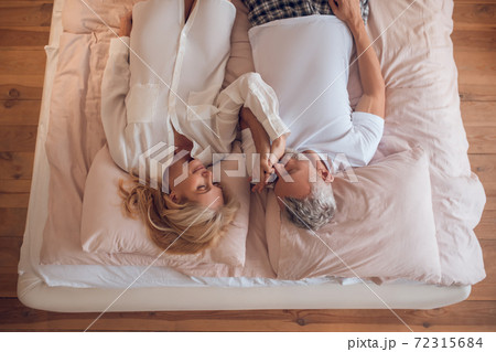 Married couple lying on a bed and looking peaceful 72315684
