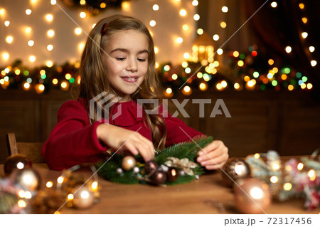 little child girl makes a handmade Christmas wreath little child girl makes a handmade Christmas wreath 72317456