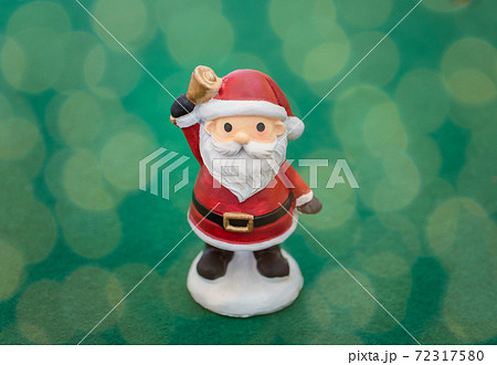 クリスマスのイメージ画像 光の玉に包まれたサンタクロースの人形の写真素材