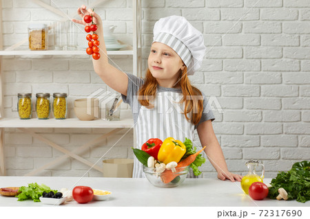 little child girl holding bowl of fresh vegetables 72317690