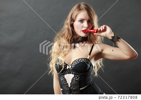 Woman wearing sexy lingerie holding chilli pepper Woman wearing sexy lingerie holding chilli pepper 72317808