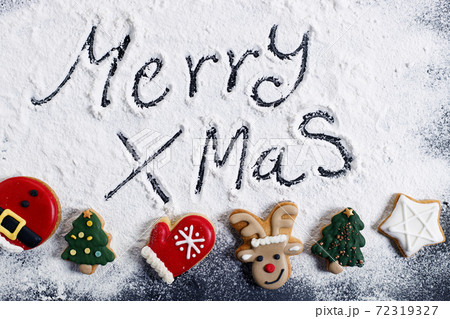 Merry Christmas, handwriting, on flour background with Christmas cookies 72319327