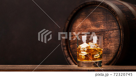 Scotch whiskey glass and old wooden barrel 72320745