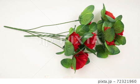 Artificial textile red carnations on white background 72321960