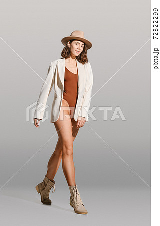 Pretty woman walking in bodysuit, blazer, hat and fishnet tights Pretty woman walking in bodysuit, blazer, hat and fishnet tights 72322299