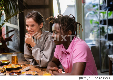 Happy young couple in cafe, having a great time with their frien Happy young couple in cafe, having a great time with their frien 72323593