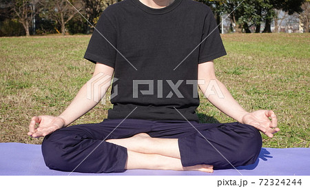 公園でヨガマットを敷いてヨガ男子が瞑想ポーズ チンムドラー ニャーナ ムドラー の写真素材