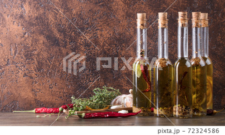 Bottles of olive oil with different spices and herbs. Bottles of olive oil with different spices and herbs. 72324586