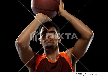 Young african basketball player training on black studio background. 72325522