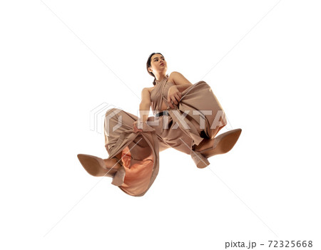 Young stylish woman in modern street style outfit isolated on white background, shot from the bottom 72325668