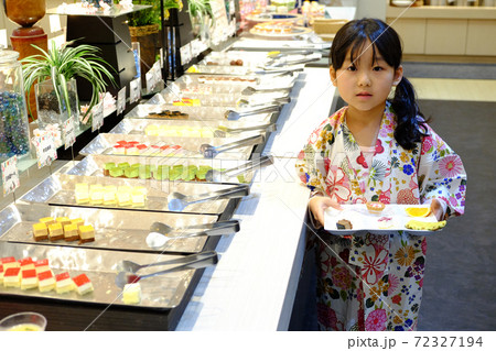 バイキング会場でケーキをとる子供 バイキング会場でケーキをとる子供 72327194
