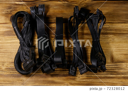 Set of cables for computer PSU on a wooden desk Set of cables for computer PSU on a wooden desk 72328012