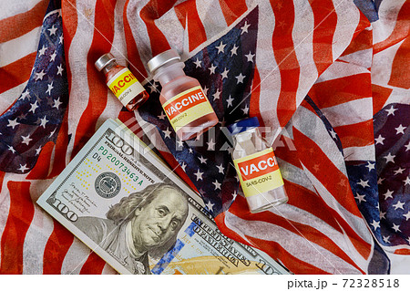American vaccine coronavirus SARS-COV-2 COVID-19 to fight in the coronavirus pandemic with the US dollar currency USA flag in the background American vaccine coronavirus SARS-COV-2 COVID-19 to fight in the coronavirus pandemic with the US dollar currency USA flag in the background 72328518