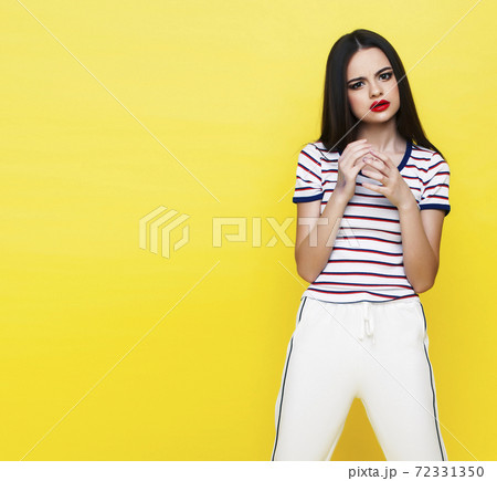 lifestyle people concept: pretty young school teenage girl having fun happy smiling on yellow background lifestyle people concept: pretty young school teenage girl having fun happy smiling on yellow background 72331350