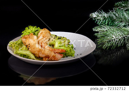 Avocado and king prawns salad on green leaves. Festive dinner New Years concept. Healthy eating. On a black reflective background. 72332712