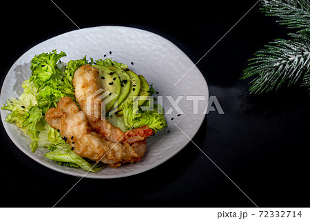 Avocado and king prawns salad on green leaves. Festive dinner New Years concept. Healthy eating. On a black reflective background. 72332714