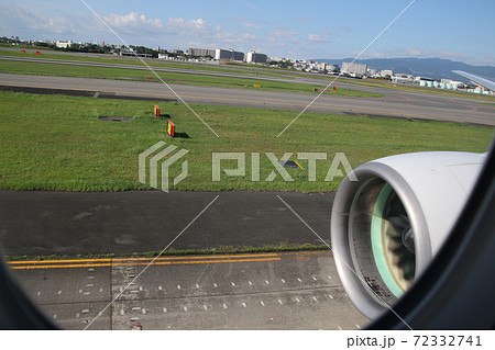 伊丹空港の誘導路をタキシング中の新千歳空港行きのボーイング767 伊丹市内や六甲山が見えるの写真素材