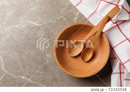 Towel with wooden kitchenware on gray table Towel with wooden kitchenware on gray table 72333556